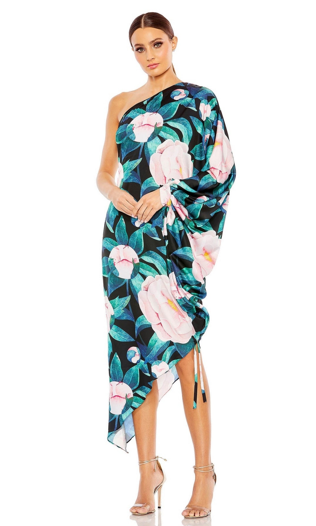 Woman wearing the Mac Duggal 11404 short print wedding guest dress with a bold pink floral pattern and one-shoulder design, styled with strappy high-heeled sandals.